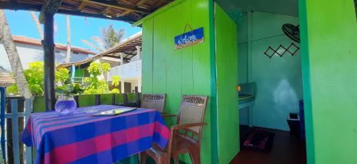 une table et des chaises devant un bâtiment vert dans l'établissement luna beach home & cabanas, à Galle
