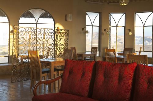 a dining room with a table and chairs and windows at Arava Land in Zuqim