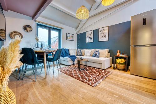 een woonkamer met een tafel en een bank bij Ashcroft Loft by Apricity Property - Stunning 3 Bedroom, 2 bathrooms, Cosy Central Apartment with balcony in Cirencester