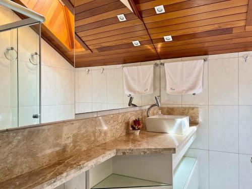 y baño con lavabo y ducha. en Apartamentos Solar da Colina CENTRO by Achei Gramado, en Canela