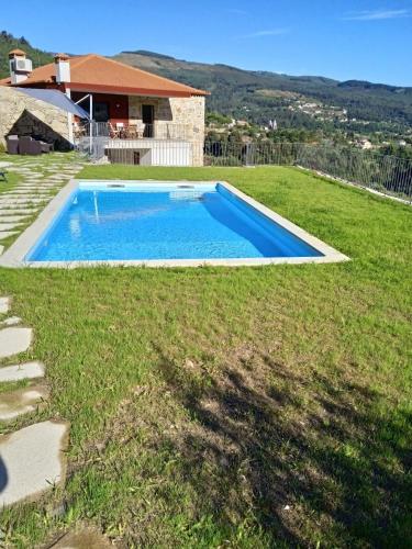 a swimming pool in the yard of a house at Casa Da Belina : casa de ferias com piscina, Labruja, Ponte de Lima in Ponte de Lima