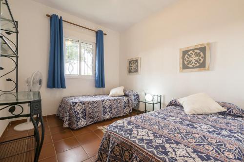 two beds in a room with blue curtains at Luna de La Barrosa in Chiclana de la Frontera