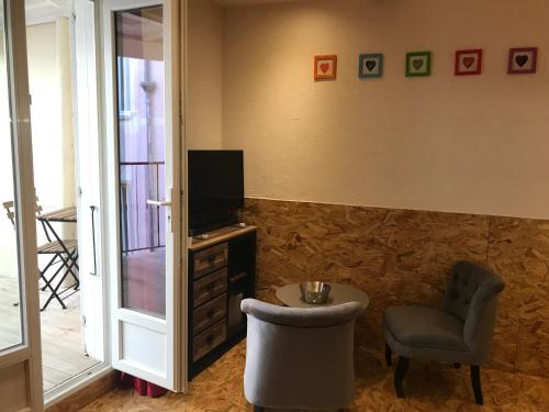 - un salon avec une chaise, une télévision et un tabouret dans l'établissement New Boat, à Narbonne