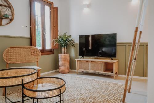 sala de estar con 2 sillas y TV de pantalla plana en Casa Los Yayos by Nomad Stays, en Altea
