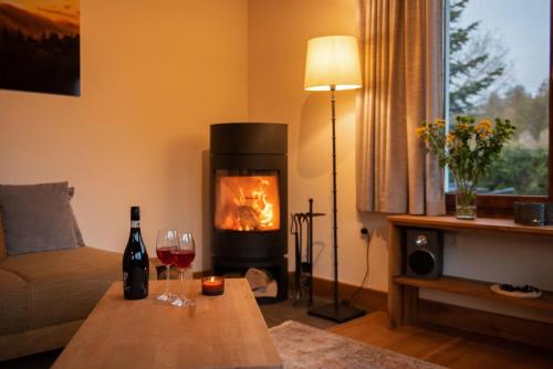 a living room with a fireplace and a table with wine glasses at Ferienhaus Rothaarblick in Schmallenberg