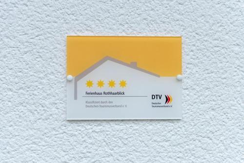 a yellow and white sign with a house on it at Ferienhaus Rothaarblick in Schmallenberg