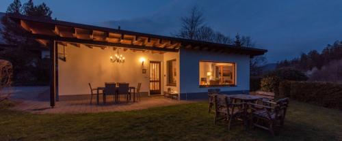 a small house with a patio with tables and chairs at Ferienhaus Rothaarblick in Schmallenberg