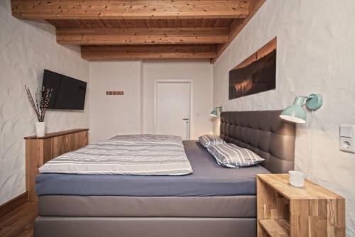a bedroom with a bed and a tv on a wall at Ferienhaus Rothaarblick in Schmallenberg