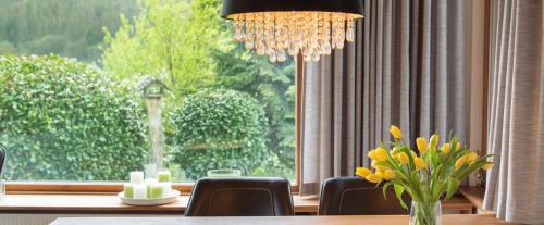 a dining room with a table and a vase of yellow flowers at Ferienhaus Rothaarblick in Schmallenberg