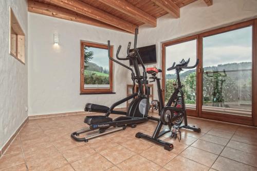 a gym with two exercise bikes in a room with windows at Ferienhaus Rothaarblick in Schmallenberg