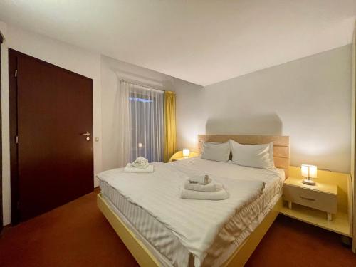 a bedroom with a bed with two towels on it at Vila Condor in Poiana Brasov