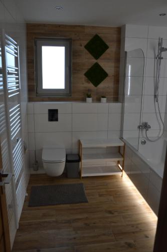 ein Bad mit einer Dusche, einem WC und einem Fenster in der Unterkunft Bungalow in Liptovský Ján