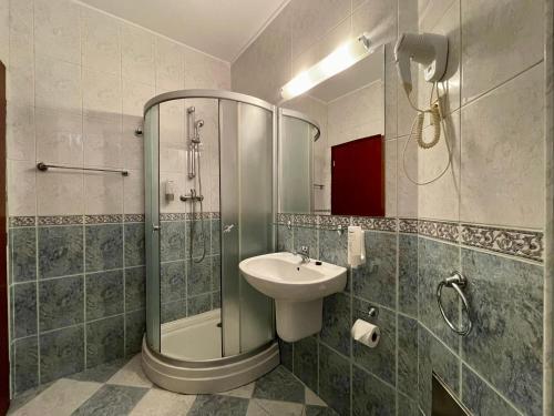 a bathroom with a sink and a shower and a toilet at Vila Condor in Poiana Brasov