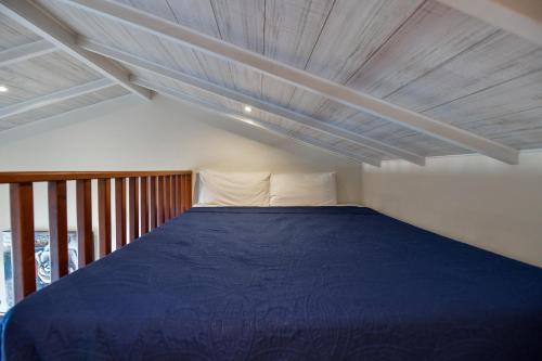 a bedroom with a blue bed with a wooden ceiling at Boutique Hotel Swiss Paradise Aruba Villas and Suites in Palm-Eagle Beach
