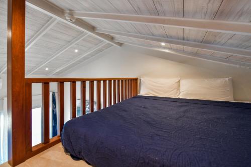 a bedroom with a blue bed with a wooden ceiling at Boutique Hotel Swiss Paradise Aruba Villas and Suites in Palm-Eagle Beach