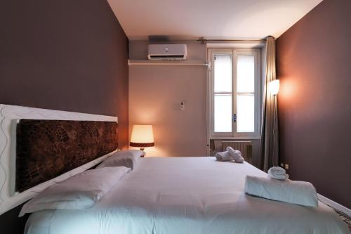 ミラノにあるPrimoPiano - Battaglia Aのベッドルーム(大きな白いベッド1台、窓付)