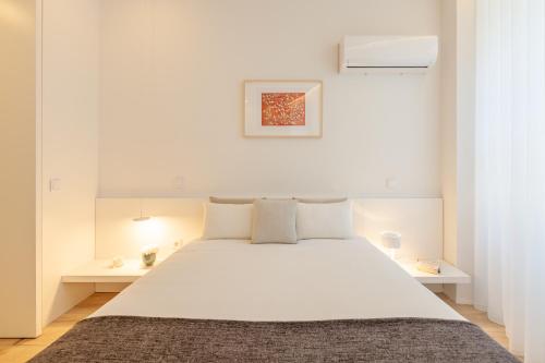 - une chambre blanche avec un grand lit blanc et des oreillers blancs dans l'établissement Boavista Collection Studio - Minho's Guest, à Braga