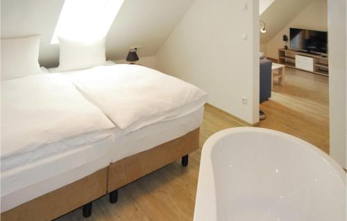 1 dormitorio con 1 cama blanca y 1 silla blanca en Fewo Burg Stargard, en Kaschow