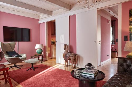 a living room with pink walls and a dog statue in it at Landhaus Jenischpark in Hamburg