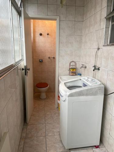 a small bathroom with a washer and a toilet at Praia Gonzaga, Santos in Santos