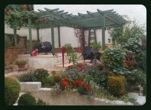 a garden with a pergola and chairs and flowers at Room in a neoclassical house - ladybug in Kastoria