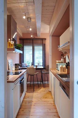 a kitchen with a long hallway with a table at Landhaus Jenischpark in Hamburg