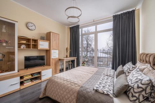 1 dormitorio con cama y ventana grande en Grizinkalns residence with free parking, en Riga