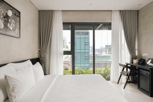 胡志明市的住宿－Triple E Hotel Metro Ben Thanh，一间卧室配有一张床和一张带窗户的书桌