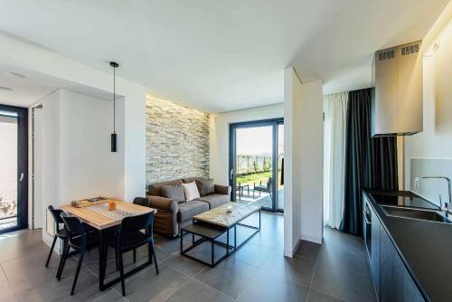 eine Küche und ein Wohnzimmer mit einem Tisch und einem Sofa in der Unterkunft Acquarella Resort in Trevignano Romano