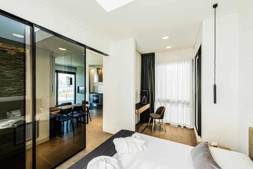 1 Schlafzimmer mit einem weißen Bett und einem Esszimmer in der Unterkunft Acquarella Resort in Trevignano Romano