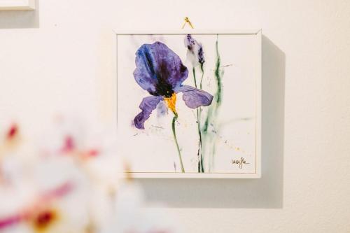 a painting of a blue flower on a wall at Ferienwohnung Lanz 1 in Lana