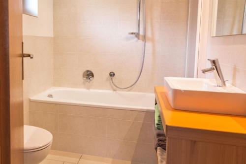 a bathroom with a tub and a sink and a toilet at Ferienwohnung Lanz 3 in Lana