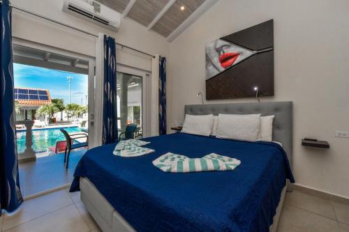a bedroom with a bed and a view of a pool at Boutique Hotel Swiss Paradise Aruba Villas and Suites in Palm-Eagle Beach