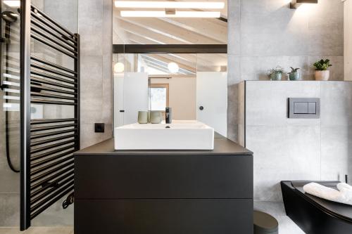 Luxus Penthouse Zentral by A-Appartments في براند: حمام مع حوض أبيض ومرآة