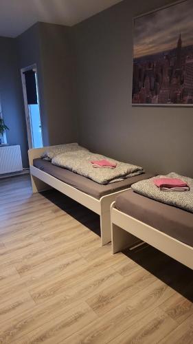 two beds in a room with a wooden floor at Flensburg Strandnah in Flensburg