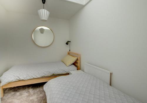 a bedroom with two beds and a mirror at Pontcanna Mews in Cardiff