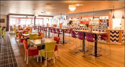 een restaurant met tafels en stoelen en een bar bij Olive-Grove in Kent