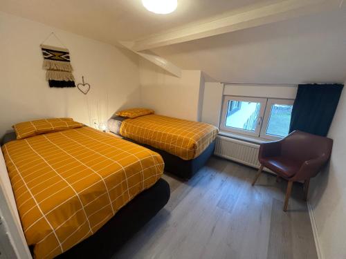 a room with two beds and a chair in it at Apartment Top van Epen in Epen