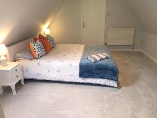 a bedroom with a large bed and a night stand at Stunning Cottage on the Edge of the Cotswolds in Charfield