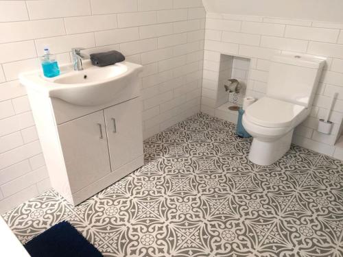 a bathroom with a sink and a toilet at Stunning Cottage on the Edge of the Cotswolds in Charfield