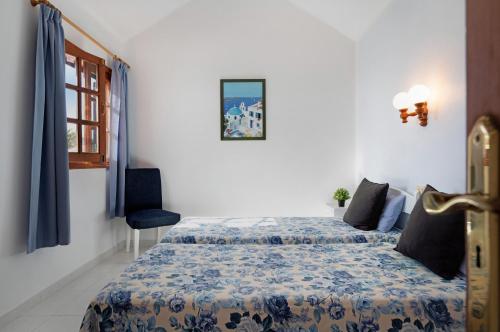 a bedroom with a bed with a blue and white comforter at Casa Aloe in Haría