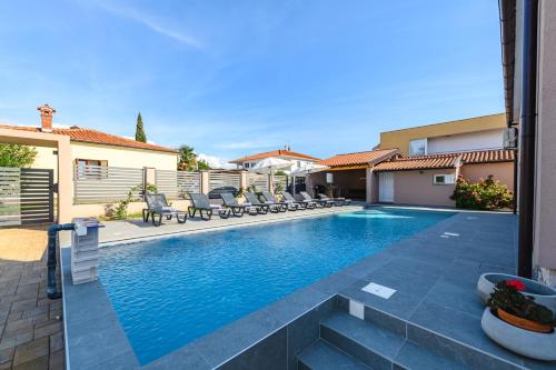 a swimming pool in a house with chairs around it at Villa Jolanda in Umag