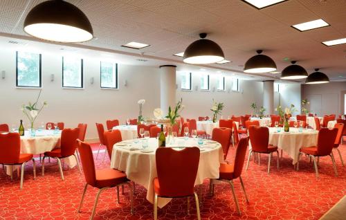 una sala conferenze con tavoli, sedie e luci di Crowne Plaza Montpellier Corum, an IHG Hotel a Montpellier