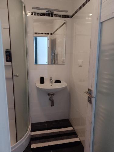 a white bathroom with a sink and a shower at UBYTOVANIE POD GERLACHOM in Vysoké Tatry