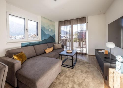 Alp Living Apartments Self-Check In في إنسبروك: غرفة معيشة مع أريكة وطاولة
