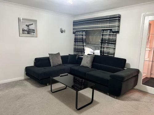 a living room with a blue couch and a table at Lovely 3 Bed Home In Glasgow with FREE Parking in Glasgow