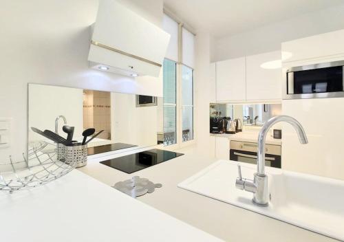 - une cuisine blanche avec des comptoirs blancs et un évier dans l'établissement Viva Riviera Overviewing Rue Hoche, à Cannes