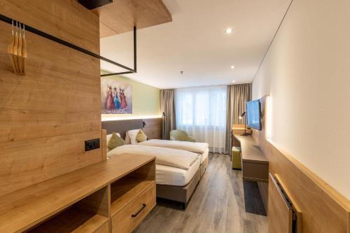 Habitación de hotel con cama y TV en Hotel Flamatt en Flamatt