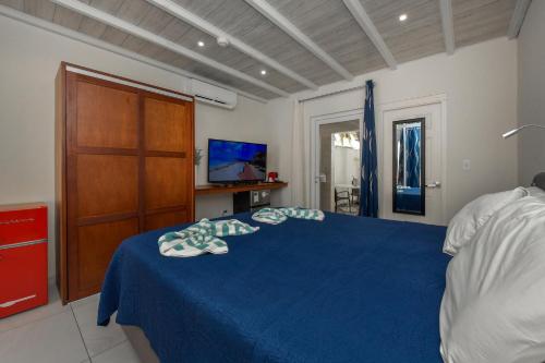 a bedroom with a blue bed and a wooden door at Boutique Hotel Swiss Paradise Aruba Villas and Suites in Palm-Eagle Beach