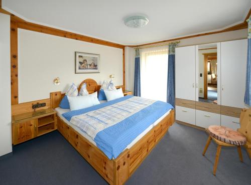a bedroom with a wooden bed and a large window at Marie Luise, Landhaus in Reith bei Kitzbühel